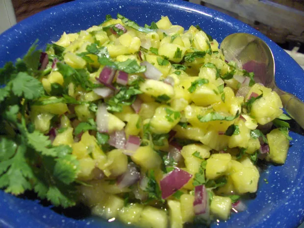 Blue speckled bowl with chunky pineapple salsa, red onion and cilantro, bright natural light